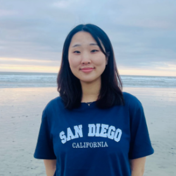 Shinae (Summer) Lee standing in front of a ocean smiling 